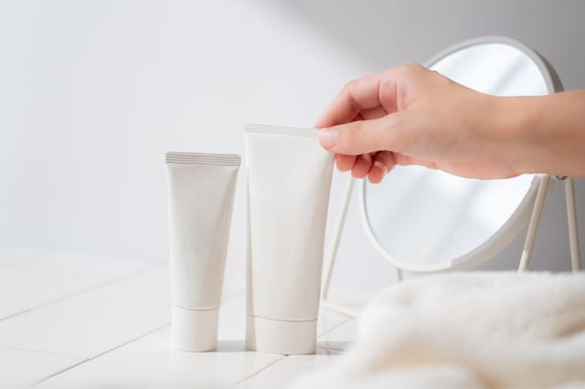 化粧品ボトルと鏡を並べたシンプルなスキンケアシーン