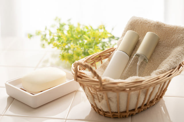 かごに入ったスキンケアボトルと石けん