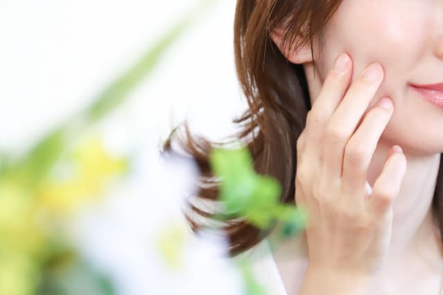 頬に触れて肌の状態を確認する女性