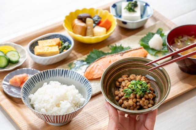 納豆や野菜が並ぶ朝食の食卓
