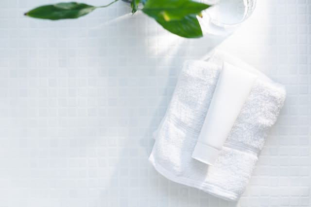 タオルとスキンケアボトルを並べた清潔感のある洗面台