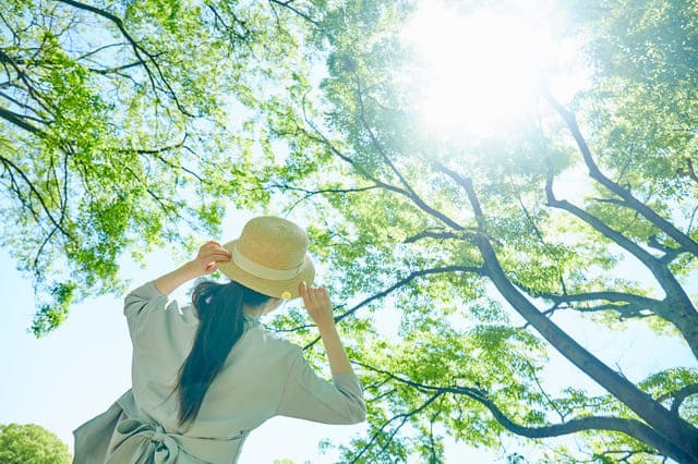 日差しの下で帽子をかぶる女性
