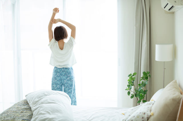 朝の光の中でストレッチをする女性