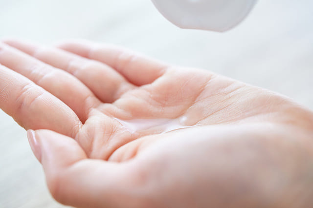 手のひらに化粧水を出すスキンケアの様子