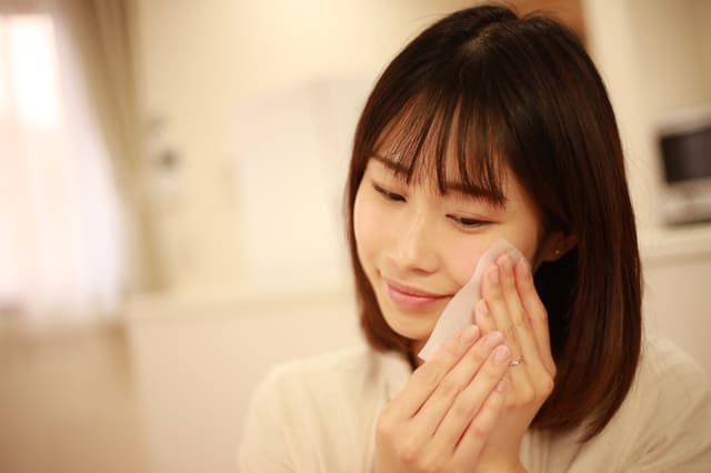 洗顔後に顔を手で包み込みスキンケアをする女性
