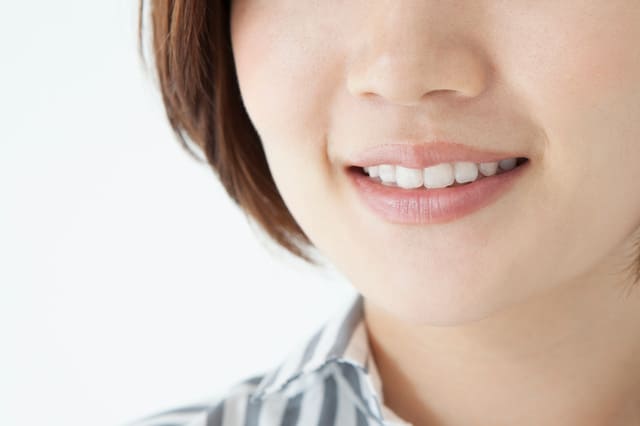 笑顔を見せる女性の口元アップ