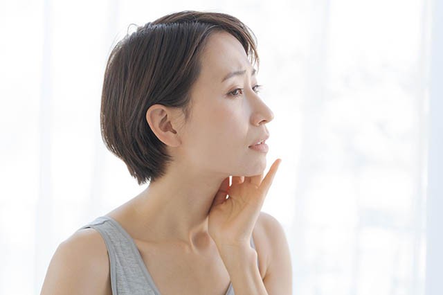 乾燥肌トラブルをチェックする40代女性
