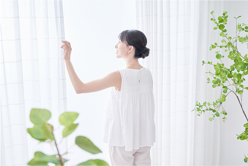 窓から外を見る女性