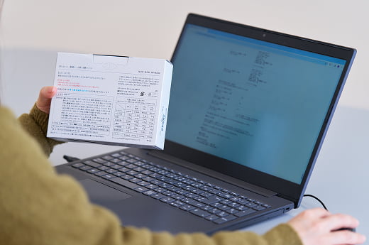 パソコンの画面と製品の表示を確認している様子